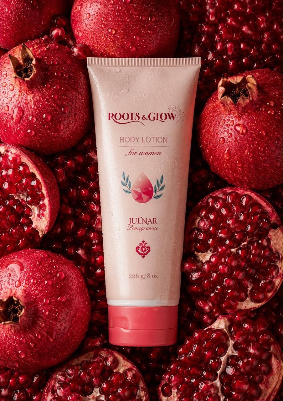 Julnar Body Lotion for women resting on a bed of split pomegranates.